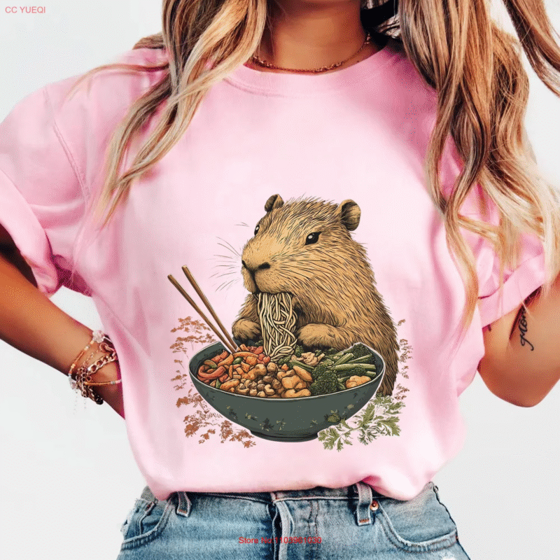 This is an animal food lover's shirt. This is a capybara, the goofy giant rodent, who is doing the munching, and she is eating ramen.